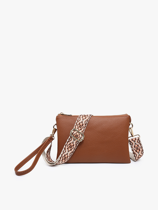 Cognac brown pebbled leather crossbody bag with detachable patterned strap and wristlet handle.