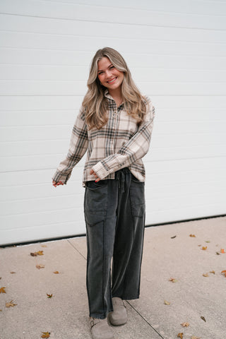 Smiling model in the khaki multi plaid button up top showing the boxy, cropped fit
