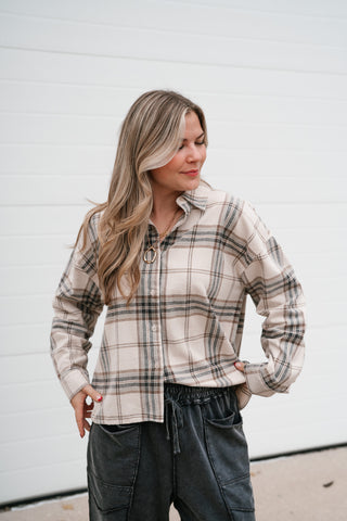 Waist-up view of the cream plaid button down shirt with collar and drop shoulders