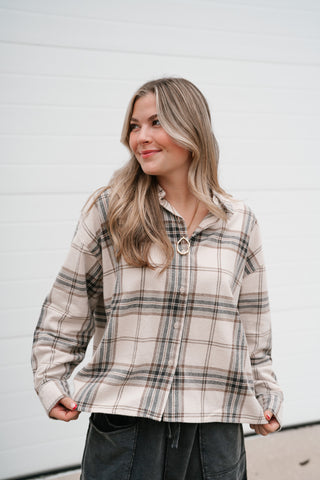 Front view of the boxy khaki plaid button down top with long sleeves and drop shoulders