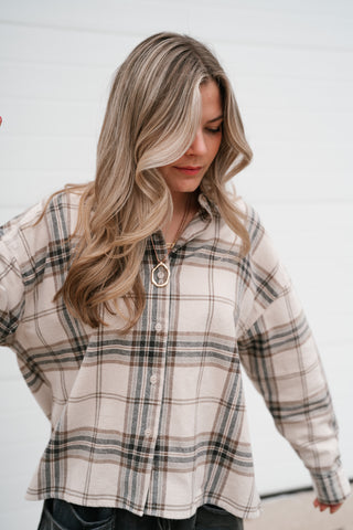 Model looking down in the relaxed khaki plaid long sleeve shirt