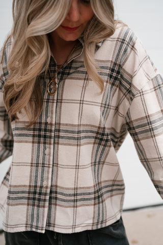 Close-up of the khaki multi plaid pattern and drop shoulder on the Tessa button down top