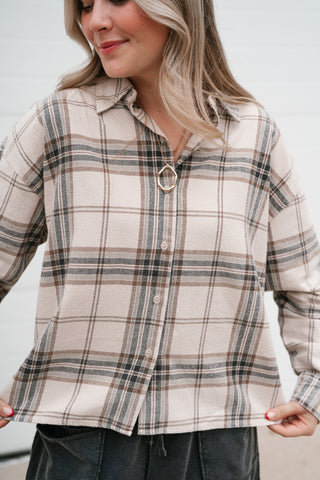 Close-up front view of the boxy cream plaid button down shirt showing the straight hem