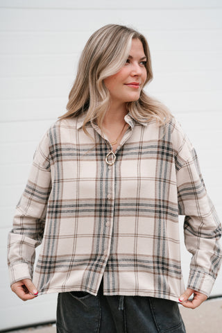 Front view of the khaki plaid button up top with long sleeves and a relaxed boxy fit