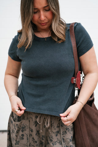 Close-up front view of the fitted black ribbed crew tee tucked into drawstring pants