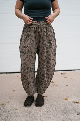 Front view of the Maisie relaxed mocha floral print barrel pants with drawstring waist and black clogs