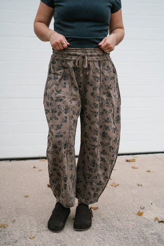 Model wearing the brown floral print barrel leg pants with a fitted dark tee