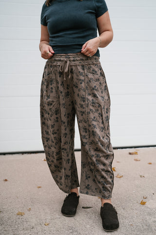 Angled view of the taupe floral barrel pants with drawstring waist and front pockets