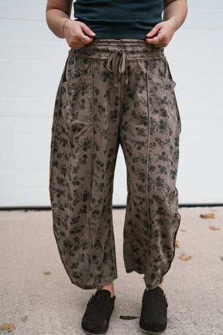 Close-up front view of the mocha floral barrel pants showing the elastic drawstring waist and exposed seams