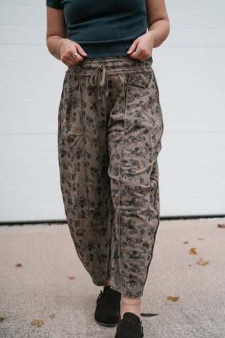 Angled front view of the mocha floral print barrel pants with drawstring waist