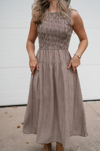Waist-down view of the brown gingham dress showing the smocked bodice, waist seam and A-line tiered skirt