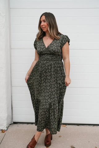 Front view of the Evergreen Fields floral midi dress with smocked waist, worn with clogs