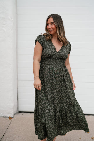 Model in the olive floral tiered midi dress with the skirt in motion
