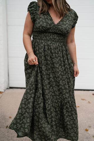 Three-quarter view of the dark green floral V-neck dress with flutter sleeves and tiered skirt