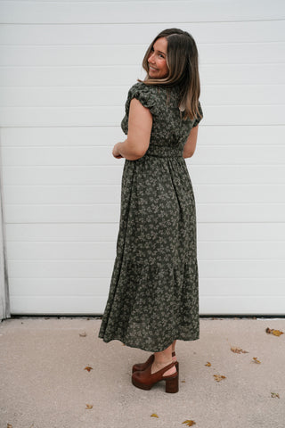Side view of the olive green floral V-neck midi dress showing the tiered skirt length