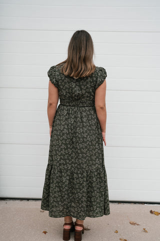 Back view of the olive floral V-neck midi dress with smocked waist and tiered skirt