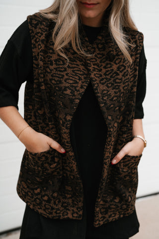 Close-up front view of the leopard print vest showing the patch pockets and curved hem