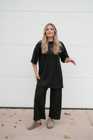Full-length view of the black ribbed lounge set with oversized top and wide leg pants