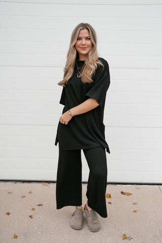 Full-length front view of the black ribbed tunic top with side slits and matching pants