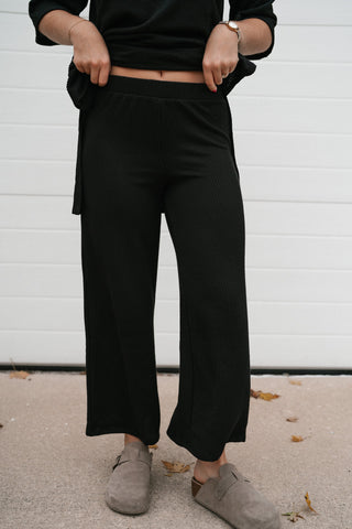 Close-up front view of the black ribbed high waisted lounge pants
