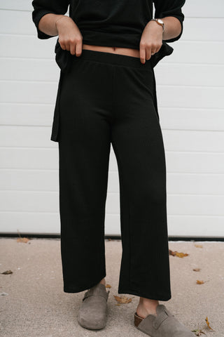 Front view of the black ribbed high waisted wide leg pants with the matching top