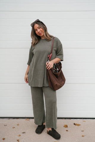 Front view of the olive green ribbed tunic tee and matching pants styled with black clogs