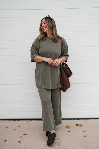Smiling model in the olive ribbed short sleeve top with the matching wide leg pants