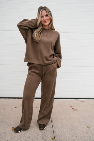 Model with a hand in her hair wearing the mocha ribbed crewneck lounge set