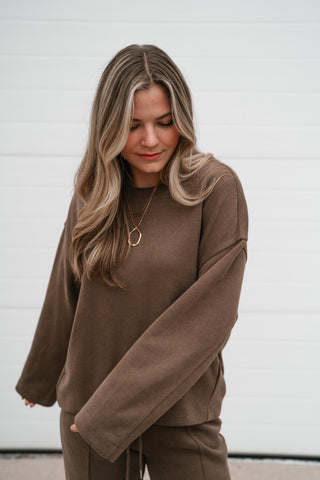 Close-up of the mocha crewneck top's drop shoulder and wide long sleeve