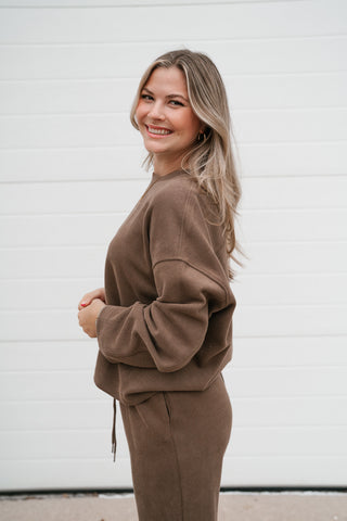 Side view of the mocha ribbed crewneck top showing the relaxed boxy fit and waist length