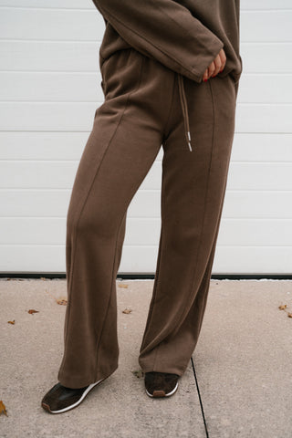 Three-quarter view of the brown ribbed lounge pants showing the center seam and full length