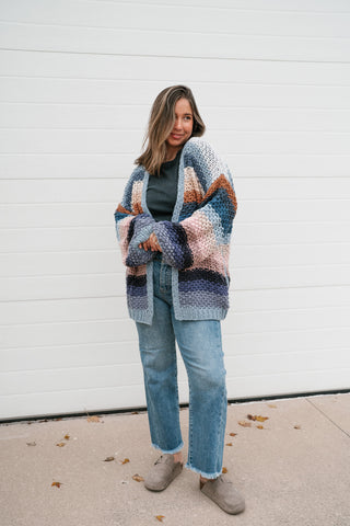 Front view of the striped crochet open cardigan with balloon sleeves, styled with light wash jeans and suede clogs
