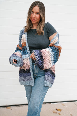 Three-quarter view of the slate blue and blush striped chunky knit cardigan with balloon sleeves