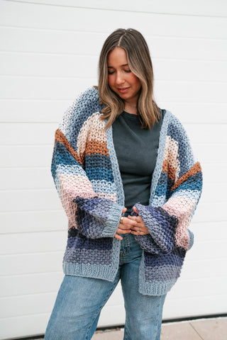 Front view of the striped crochet cardigan worn open, showing the blue, cream, blush and navy stripe pattern