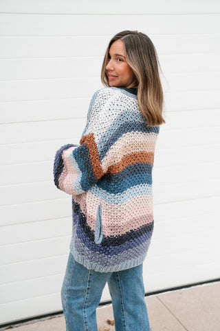 Side view of the chunky striped crochet cardigan showing the relaxed oversized fit and balloon sleeve