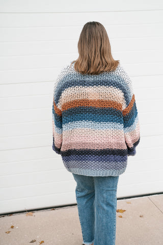 Back view of the oversized striped crochet cardigan showing the hip-length hem and stripe pattern