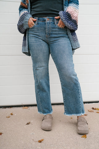 Medium wash high rise straight leg jeans styled with a striped crochet cardigan and clogs