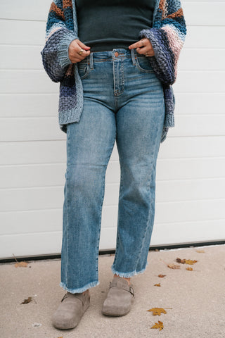 Front view of the medium wash ankle straight jeans with light fading and frayed hem
