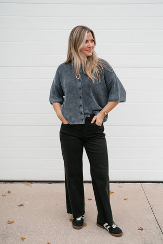 Woman wearing the Better Days navy vintage-wash ribbed knit cardigan with elbow-length sleeves and black wide-leg pants