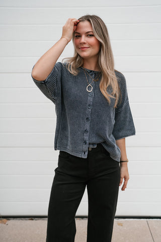 Waist-up view of the navy ribbed knit cardigan with round neckline and button front