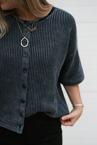 Close-up of the vintage-wash navy ribbed knit and elbow-length sleeve