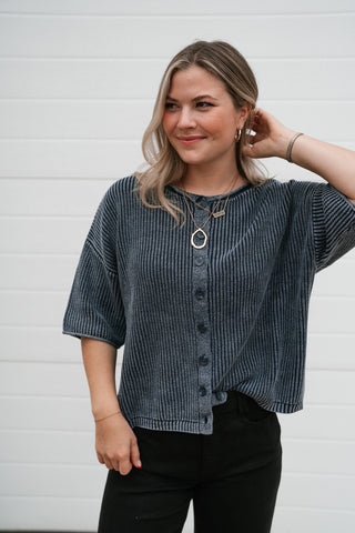 Model smiling in the navy vintage-wash cardigan with a hand in her hair