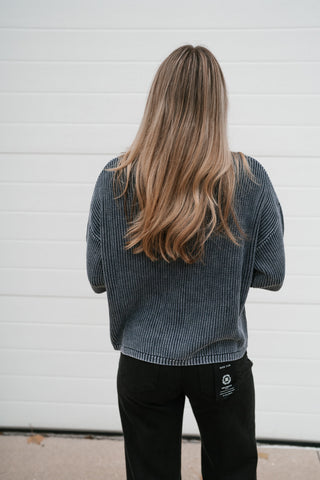 Back view of the navy short sleeve ribbed knit cardigan with drop shoulders