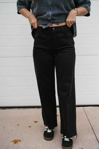 Black tummy control high rise wide leg jeans styled with a navy knit top and sneakers