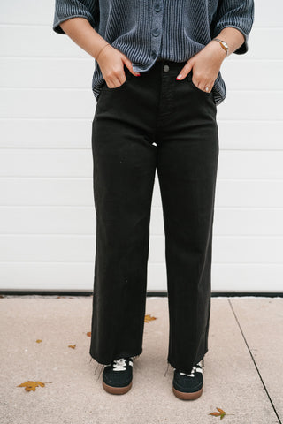 Front view of the black high rise jeans showing the crease line detail down the wide leg