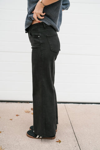 Side view of the black high rise wide leg jeans showing the fit through the hip and straight wide leg