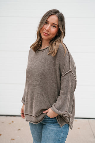Model with hand in pocket wearing the brown textured knit dolman sweater