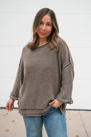 Front view of the washed brown lightweight sweater with rolled cuffs and exposed seam details