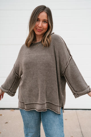 Woman wearing the Fresh Air dolman sleeve sweater in washed brown with light wash jeans