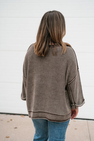 Back view of the brown dolman sleeve sweater with exposed seams and relaxed fit